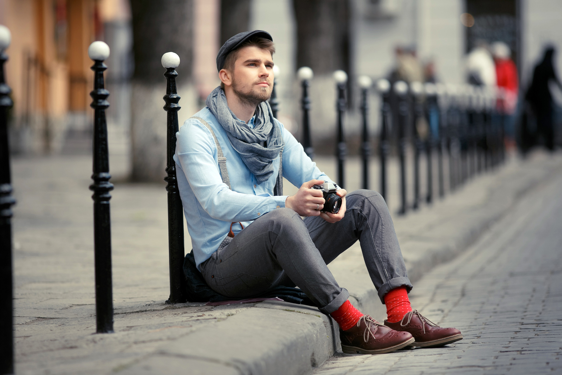 Calcetines rojos de cuadritos y pantalón de vestir sobre lodo a la orilla  de un río.